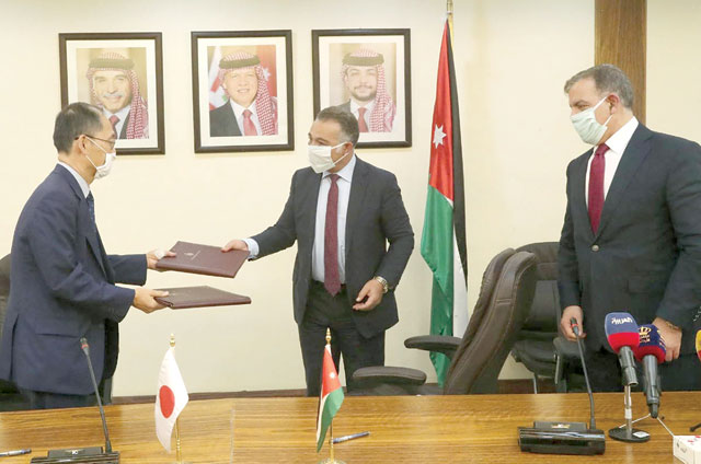 Minister of Planning and International Cooperation Wissam Rabadi and Japanese Ambassador Hidenao Yanagi exchange copies of a grant agreement in the presence of Health Minister Saad Jaber during a signing ceremony in Amman on Monday (Petra photo)
