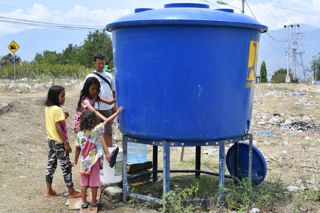 Indonesian children access usable water at a temporary camp in Palu in Central Sulawesi on Thursday, after an earthquake and tsunami hit the area on September 28 (AFP photo)