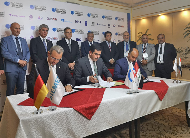 From left  to right Karim Amin, CEO of Siemens Power Generation, Waleed Khaled Hassan, director general, general state company for electricity production north region and Orascom CEO Osama Bishai, sign a contract in the Iraqi capital Baghdad, on Saturday (AFP photo)