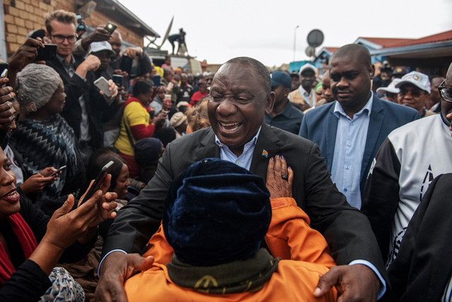 President of South Africa and the African National Congress Cyril Ramaphosa (centre) greets a voter as he arrives to cast his vote for the general elections at the Hitekani Primary School, Chiawelo, Soweto, on Wednesday  (AFP photo)