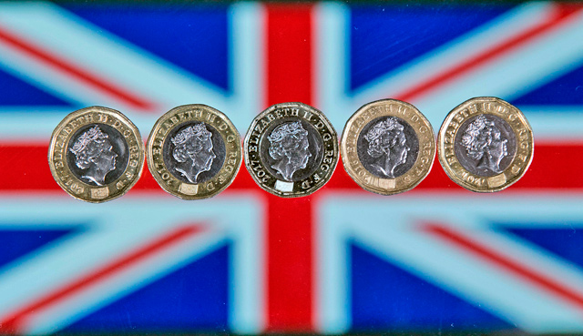 British one pound sterling coins are arranged in front of a Union flag for a photograph in London on December 14, 2017 (AFP file photo)