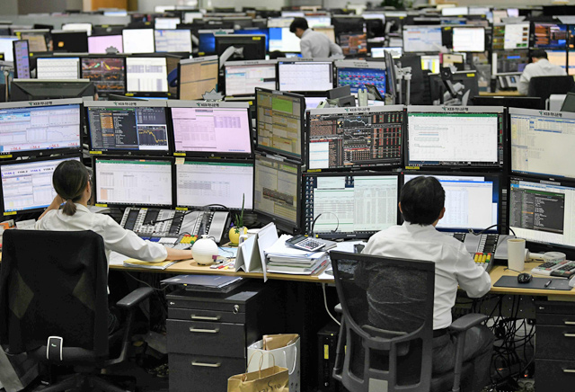Currency dealers monitor exchange rates in a trading room at KEB Hana Bank in Seoul on Monday (AFP photo)