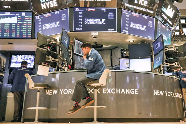 Traders work on the floor of the New York Stock Exchange on Wednesday in New York City. US investor appetite was dampened by data that suggested the central bank may raise interest rates, eroding gains from a relief rally after Tuesday's midterm elections (AFP photo)