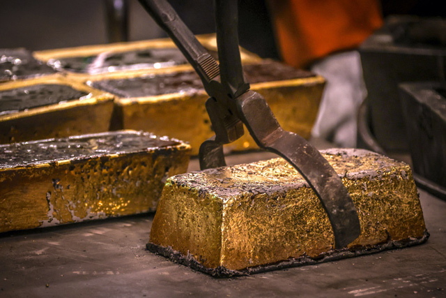 A worker places a 20 kilogramme gold brick on a tray after being removed from a cast at the ABC Refinery in Sydney, on Wednesday  (AFP photo)