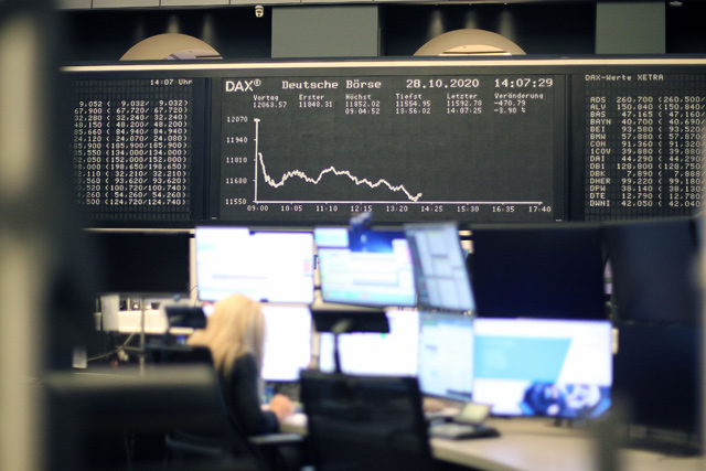 A broker sits under the display showing the evolution of the German Stock Market Index DAX is pictured at the stock exchange in Frankfurt, western Germany, on Wednesday, amid the new coronavirus COVID-19 pandemic (AFP photo)