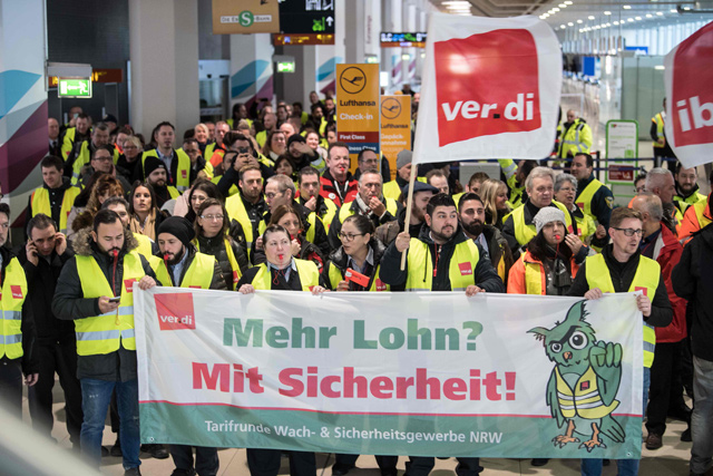 Members of Germany's Verdi union hold a banner reading ‘more pay? With security [certainty]’ at a terminal during a one-day strike by security staff at Cologne's airport on Thursday (AFP photo)