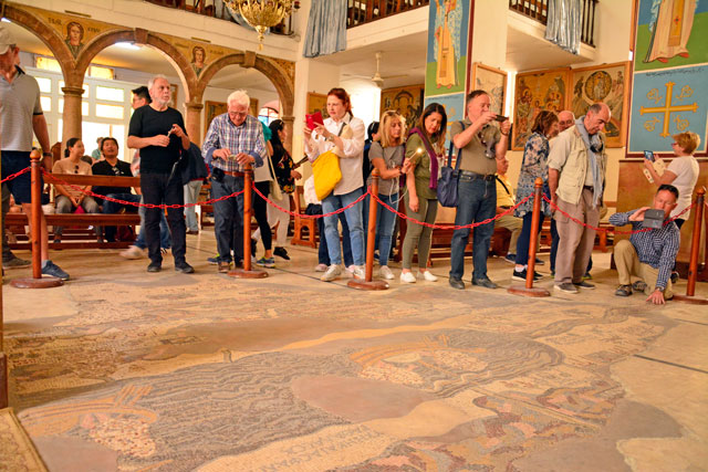Tourists at the Mosaic Map in the St George Greek Orthodox Church in Madaba, some 30km southwest of Amman (Photo by Amjad Ghsoun)