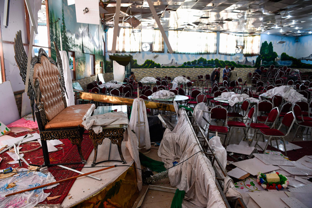 Afghan men investigate in a wedding hall after a deadly bomb blast in Kabul on Sunday   (AFP photo)