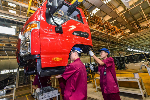 Workers produce truck parts at a factory in Qingzhou, in China's eastern Shandong province, on Wednesday (AFP photo)