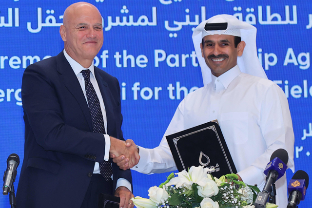 Qatar's Minister of State for Energy Affairs and President and CEO of QatarEnergy Saad Sherida Al Kaabi (right) shakes the hand of Claudio Descalzi, CEO of Italian multinational oil and gas company ENI, during a signing ceremony at the QatarEnergy headquarters in Doha on Sunday  (AFP photo)