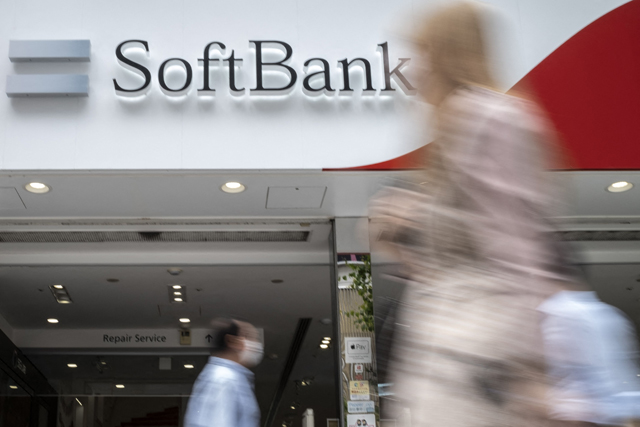 Pedestrians walk past a SoftBank mobile shop in Tokyo on Thursday (AFP photo)