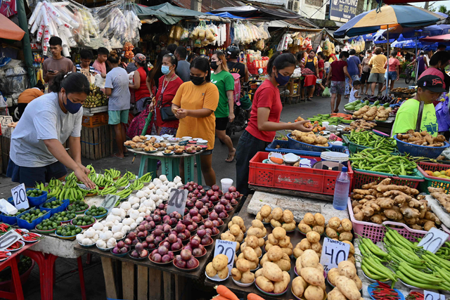 Vendors tend to their stalls as customers browse at a market in Manila on Wednesday (AFP photo)
