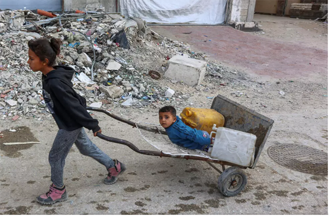 Palestinian children head to a water distribution point to fill their containers in Gaza City (AFP photo)