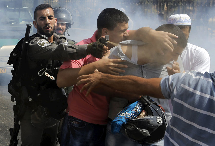 An Israeli soldier uses pepper spray on a Palestinian man during clashes near the Arab East Jerusalem neighbourhood of Wadi Al Joz on Friday (Reuters photo)