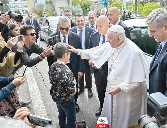Pope Francis blesses a boy after signing the cast on the boy's arm as the Pope leaves the Gemelli hospital on Saturday, in Rome, after being discharged following treatment for bronchitis (AFP photo)