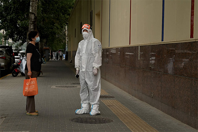 A police officer talks to a woman along a street in Beijing on Thursday (AFP photo)