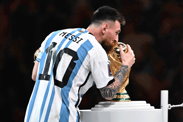 Argentina’s forward Lionel Messi holds the Golden Ball award for best player as he kisses the FIFA World Cup Trophy during the trophy ceremony at the end of the Qatar 2022 World Cup final in Lusail on Sunday (AFP photo by Anne-Christine Poujoulat)