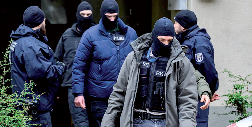 An officer of the German Federal Criminal Police Office (BKA) (front) leaves a building, on Tuesday, believed to be the site where a German activist of the notorious far-left Red Army Faction (RAF) wanted for more than 30 years for attempted murder and other crimes has been arrested in Berlin (AFP photo)