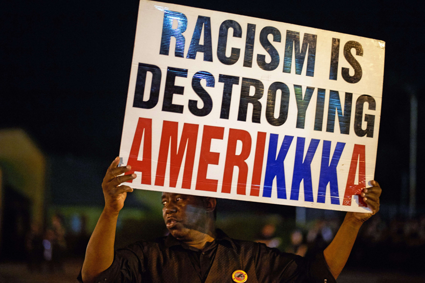 A man holds a sign during a civil disobedience action on West Florissant Avenue in Ferguson, Missouri, on Monday (AFP photo)