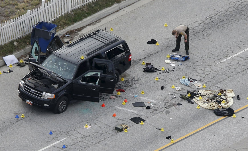 A law enforcement officer looks over the evidence near the remains of a SUV involved in the Wednesday attack is shown in San Bernardino, California, on Thursday (Reuters photo)