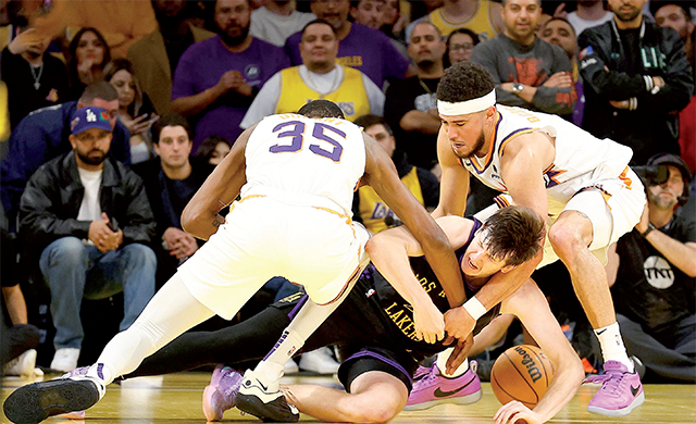 Justin Reaves #15 of the Los Angeles Lakers is defended by Kevin Durant #35 and Devin Booker #1 of the Phoenix Suns in the second half during the 2023 NBA In-Season Tournament quarterfinals at Crypto.com Arena on Wednesday in Los Angeles, California (AFP photo)