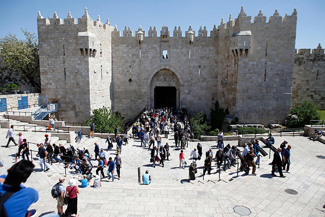 Palestinians walk next to Damascus Gate, a main entrance to Jerusalem's Old City, before the Friday’s prayer at Al Aqsa Mosque/Al Haram Al Sharif (AFPphoto )
