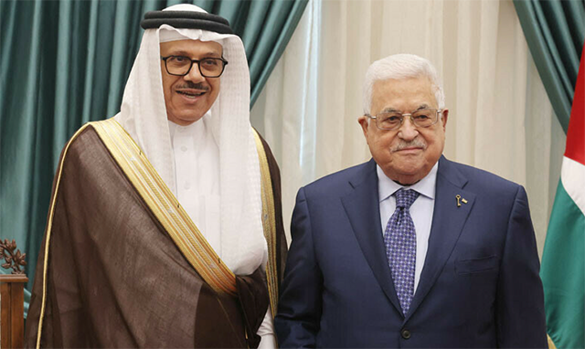 This handout photo provided by the Palestinian Authority’s press office shows Palestinian President Mahmud Abbas (right) posing for a photo with Bahrain’s Foreign Minister Abdullatif Al Zayani during their meeting in the West Bank city of Ramallah on October 29 (AFP photo)