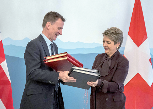 Britain's Chancellor of the Exchequer Jeremy Hunt and Swiss Finance Minister Karin Keller-Sutter exchange documents after signing an agreement on mutual recognition in financial services, in Bern, on Thursday (AFP photo)