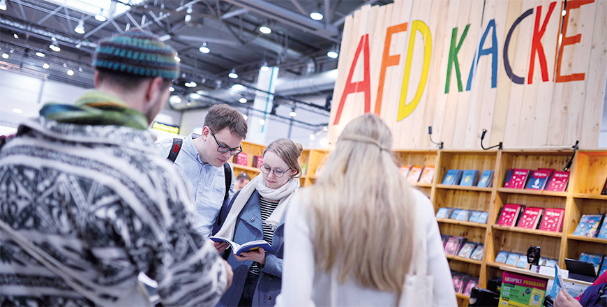 Visitors look at books as the words AFD Kack are seen in the background above the booth of Kaktus Publishing (Kaktus Verlag) on the opening day of the Leipzig Book Fair on Thursday in Leipzig, eastern Germany (AFP photo)