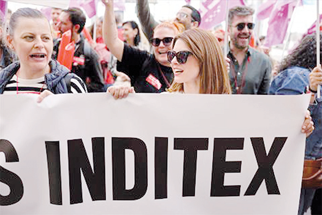 A demonstrator holds a banner during a demonstration called by unions from Inditex, the world's biggest fashion retailer, to ask for a better distribution of the group's record profits, in front of a Bershka store in Madrid, on Friday (AFP photo)