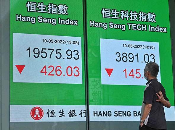 This file photo shows a man looking at a sign displaying the numbers for the Hang Seng Index before the close of trading on Tuesday as markets continue to be volatile (AFP photo)