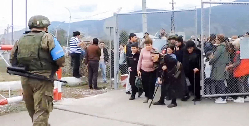 In this video grab taken from a handout footage and released by Russian Defence Ministry on Thursday, a Russian peacekeeper stands guard as Armenian civilians enter a Russian military base near Stepanakert in the Nagorno Karabakh region (AFP photo)