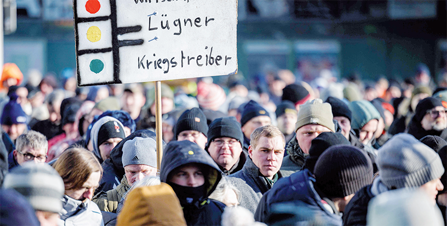 A protester holds up a poster reading 'Killers of economy - Liars - Warmongers' during a demonstration against the federal government's austerity plans in Halle an der Saale, eastern Germany, on Monday (AFP photo)
