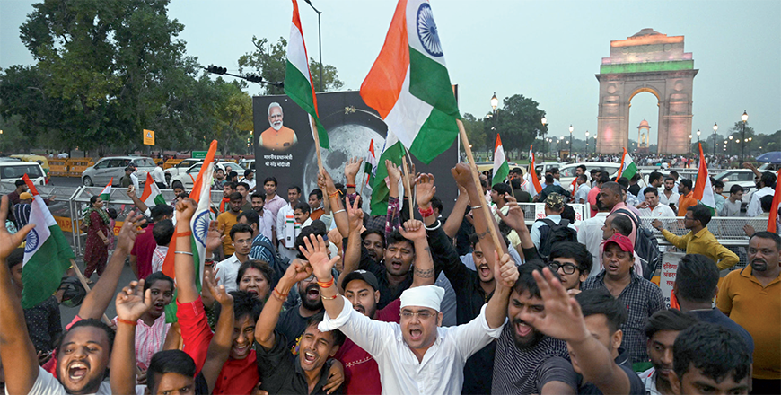People wave Indian national flags as they celebrate the successful lunar landing of Chandrayaan-3 spacecraft on the south pole of the Moon, in New Delhi, on Wednesday (AFP photo)