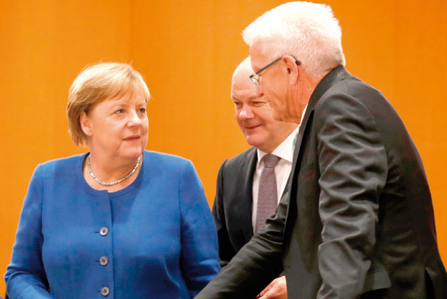 German Chancellor Angela Merkel (left) talks with Baden-Wuerttemberg's State Premier Winfried Kretschmann on Thursday in Berlin (AFP photo)