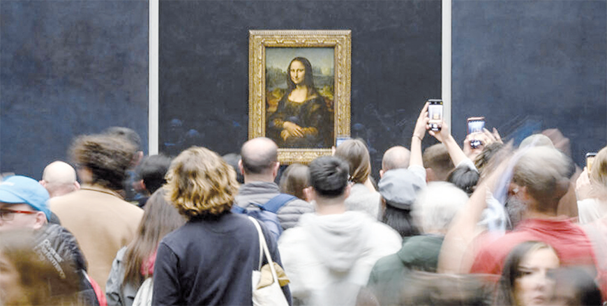 Visitors take photos of the painting La Joconde , The Mona Lisa by Italian artist Leonardo Da Vinci on display in a gallery at The Louvre Museum in Paris, on April  (AFP photo)