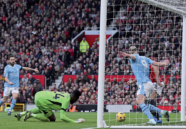 Manchester City’s Norwegian striker #09 Erling Haaland and Manchester United’s English defender #05 Harry Maguire (right) fight for the ball on the United goal-line during the English Premier League football match between Manchester United and Manchester City at Old Trafford in Manchester, north west England, on Sunday (AFP photo)