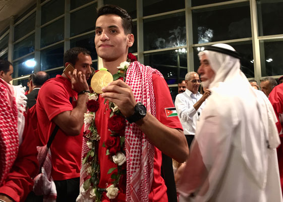 Taekwondo champion Ahmad Abu Ghaush shows his gold medal at the Queen Alia International Airport on Tuesday  (Photo by Muath Freij)