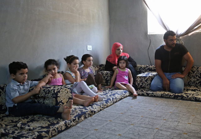 Mohamed Ghazal (right), a Syrian refugee, sits with his family on August 9, in a home in the northern Jodanian town of Irbid where they are being housed under a programme working in collaboration with a Norwegian NGO and local property owners (AFP photo)