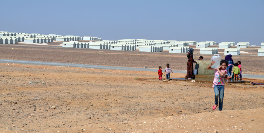 In this file photo from August 2014, Syrian refugees carry water at the Azraq Refugee Camp, some 100km east of Amman and 20km west of the town of Azraq in Zarqa Governorate (Photo by Muath Freij)