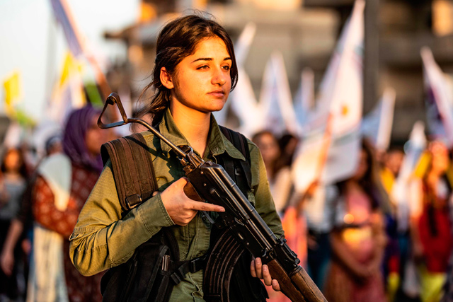   A member of the Kurdish Internal Security Police Force of Asayish stands guard as Syrian Kurdish demonstrate against Turkish threats to invade the Kurdish region, in the northeastern city of Qamishli on August 27 (AFP photo)