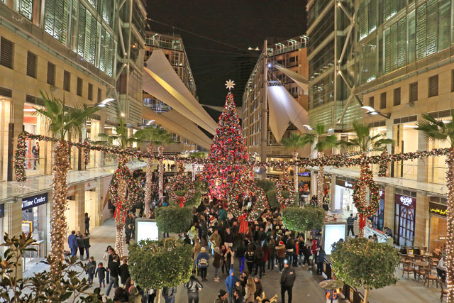 Visitors are seen near the Christmas tree at The Boulevard in Abdali on Thursday night (Photo by Osama Aqarbeh)