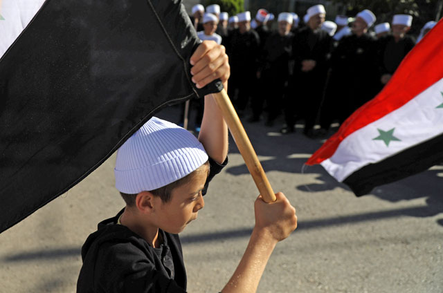 Druze hold Syrian flags during a rally in Buq'ata on Thursday. It was reported that Daesh kidnapped women and children during their attack last week (Reuters  photo)