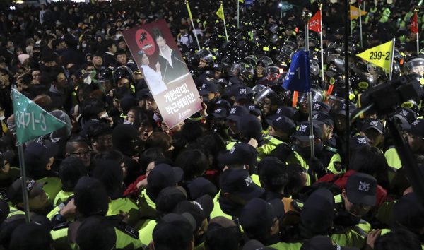 South Korean protesters are blocked by police officers after a rally calling for President Park Geun-hye to step down in downtown Seoul, South Korea, on Saturday (AP photo)