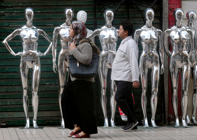 People walk next to mannequins outside shops in Cairo on Sunday (Reuters photo)