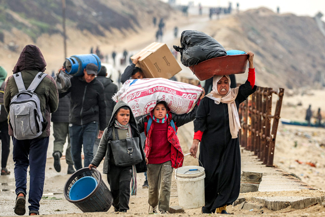 People walk with belongings along al-Rashid street between Gaza City and Nuseirat in the central Gaza Strip on February 10, 2025 as displaced people return home amid the current ceasefire deal in the war between Israel and Hamas (AFP photo)