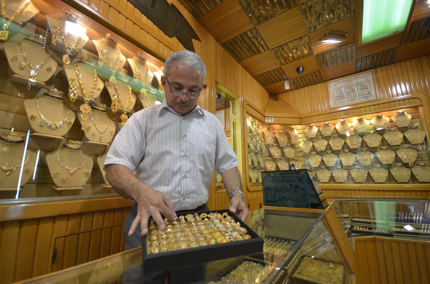 A jewellery seller arranges gold rings at his shop in Amman on Tuesday (Photo by Muath Freij)