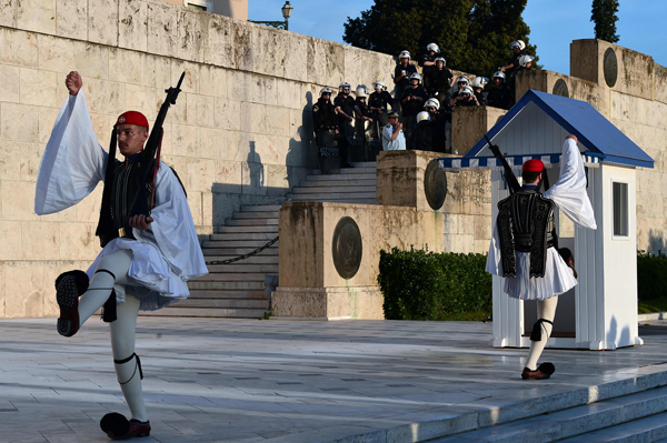 Greek police watch as Greek Evzoni change guards in front of the Greek parliament building in Athens on Sunday during a protest against the latest reform measures demanded by Greece's creditors (AFP photo)