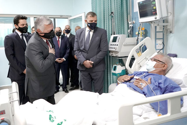 His Majesty King Abdullah, accompanied by HRH Crown Prince Hussein, checks on a patient during a tour of Al Hussein Hospital in Salt, a 350-bed, 11-storey facility, on Monday (Photo courtesy of Royal Court)