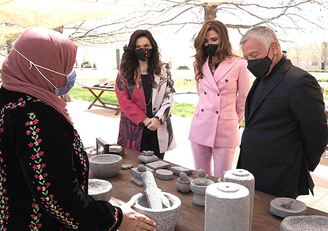 His Majesty King Abdullah, accompanied by Her Majesty Queen Rania, views sample products from beneficiaries of the Productive Youth Initiative on Tuesday (Photo courtesy of the Royal Court)